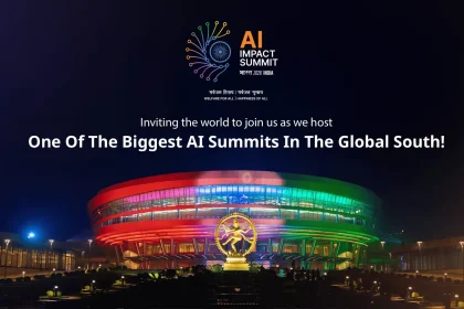 AI Impact Summit (Bharat 2026 India) tanıtım görseli; “One Of The Biggest AI Summits In The Global South!” yazısı ve gece ışıklandırılmış, renkli bir kongre/arena binası önünde heykel.